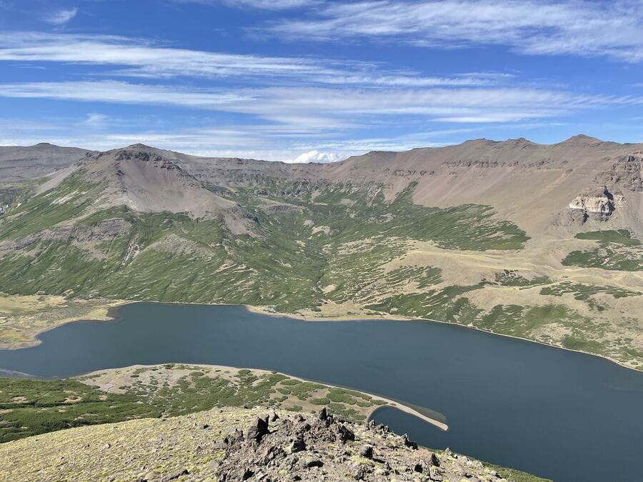 A long blue lake in a wide valley, seen from high above