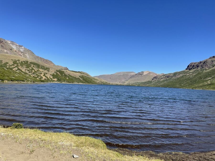 Wind-rippled lake water below brown hills