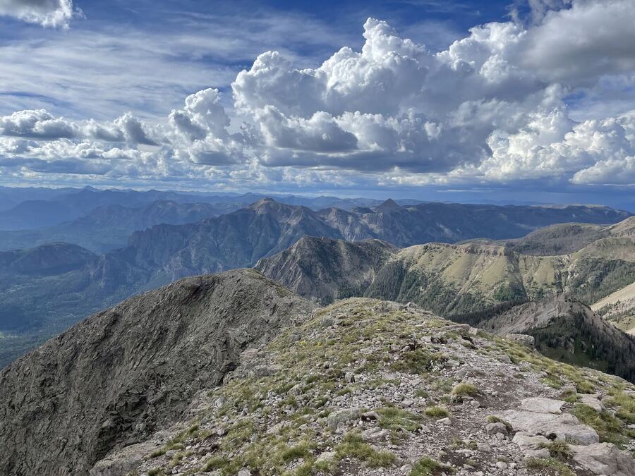 A long view over layered ridges from a stony summit