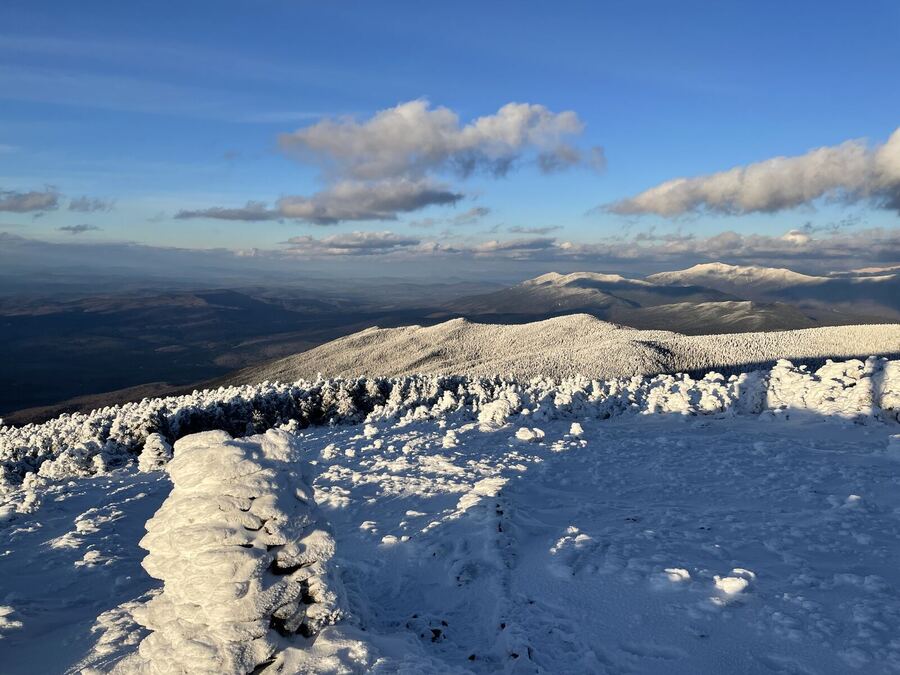 A snowy summit with rime-covered cairns and a far horizon