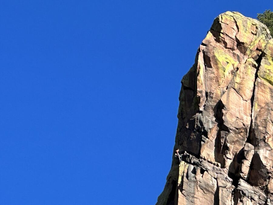 An orange rock tower against a clear blue sky