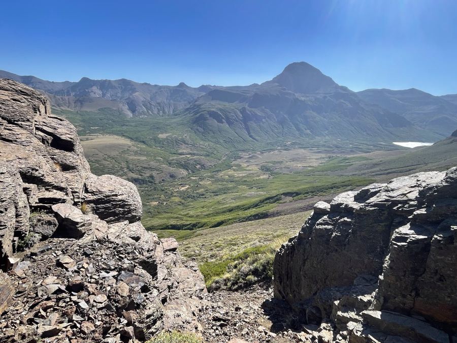 The same valley framed between two weathered rock outcrops